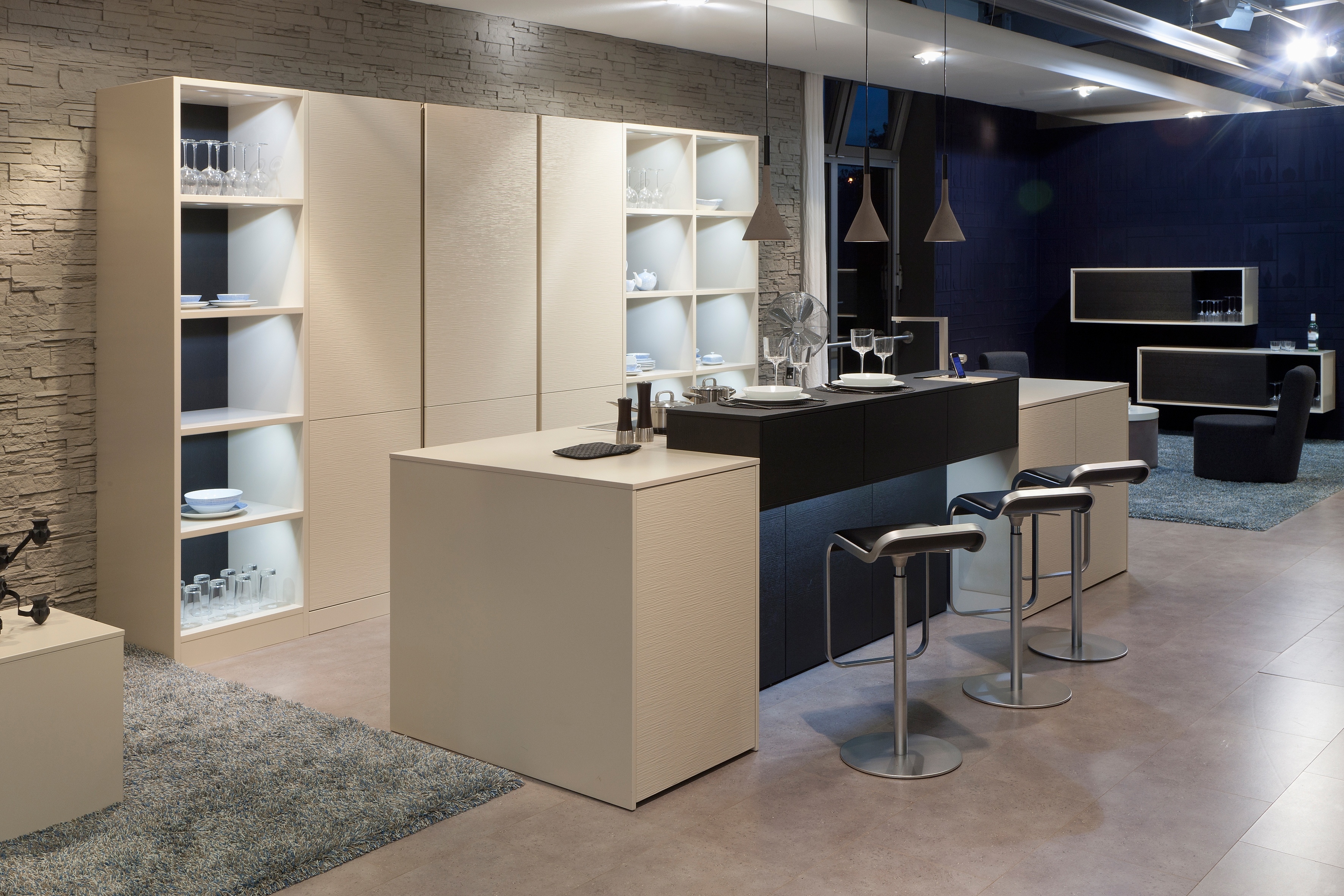 Hochränke mit Regalen und eine Insel in einem Sandton mit einem dunkel abgesetzten Tresen.