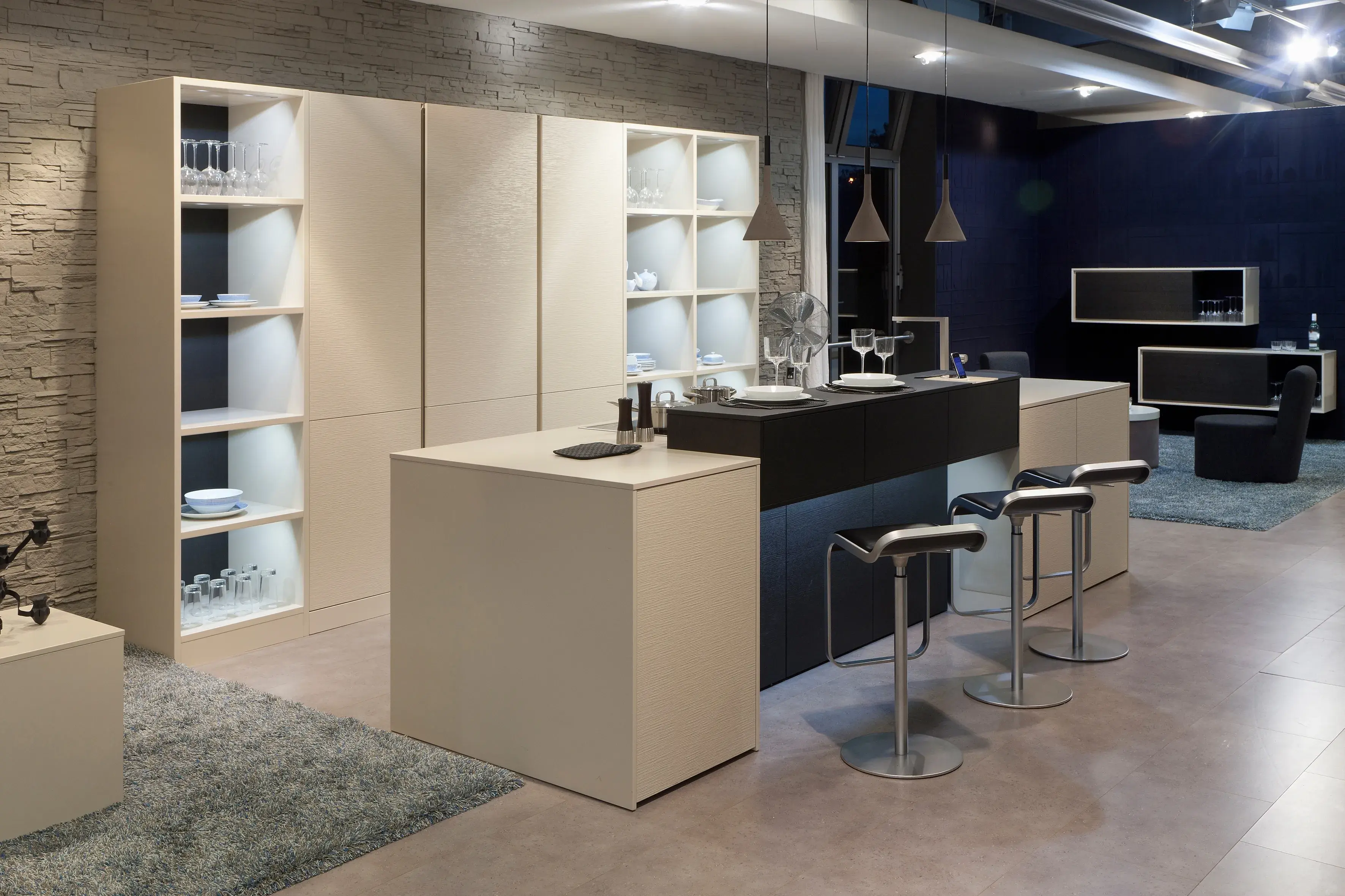 Hochränke mit Regalen und eine Insel in einem Sandton mit einem dunkel abgesetzten Tresen.