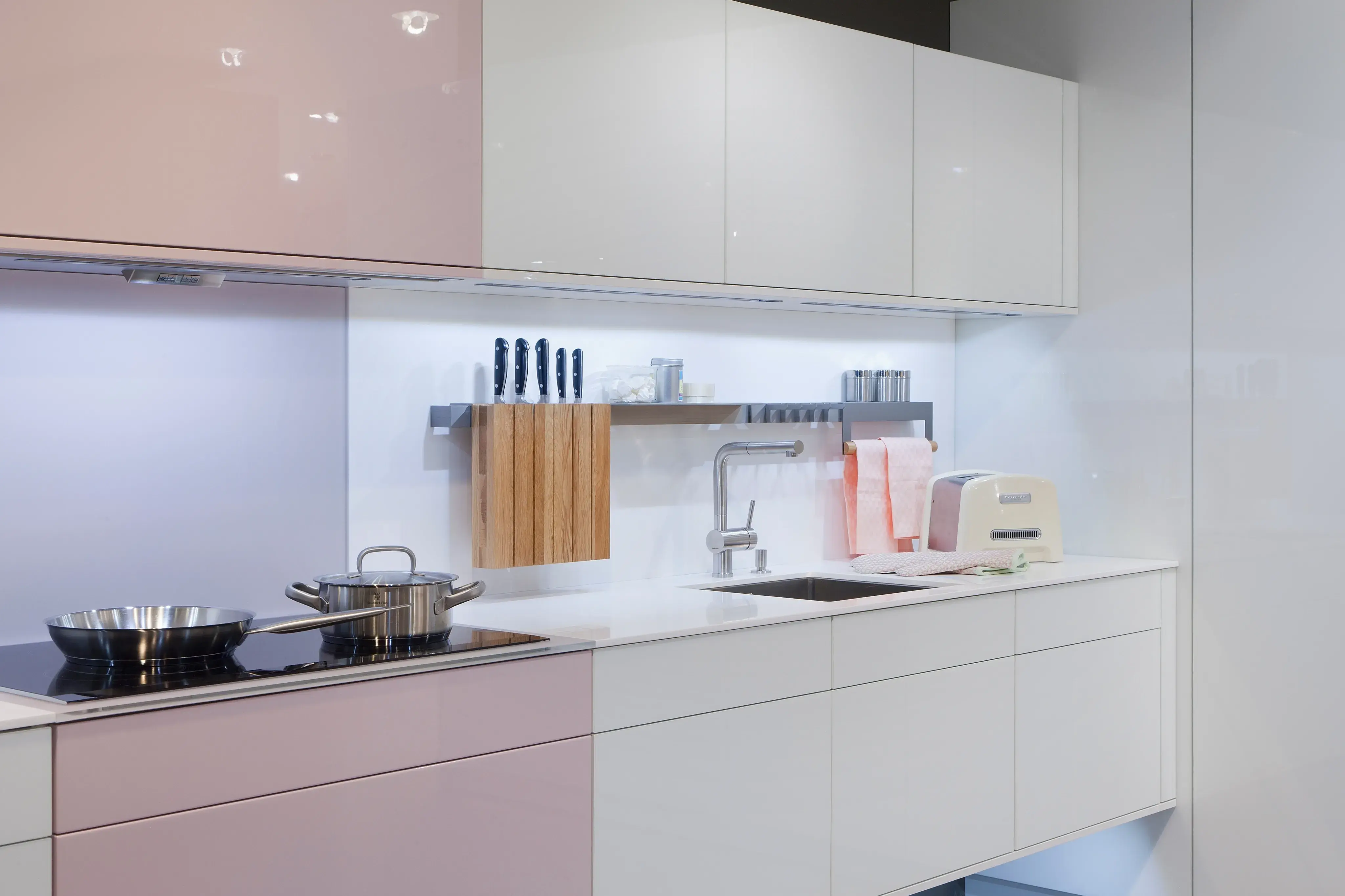 Eine schwebende Unterschrankzeile in weiß mit einem rosa Akzent.